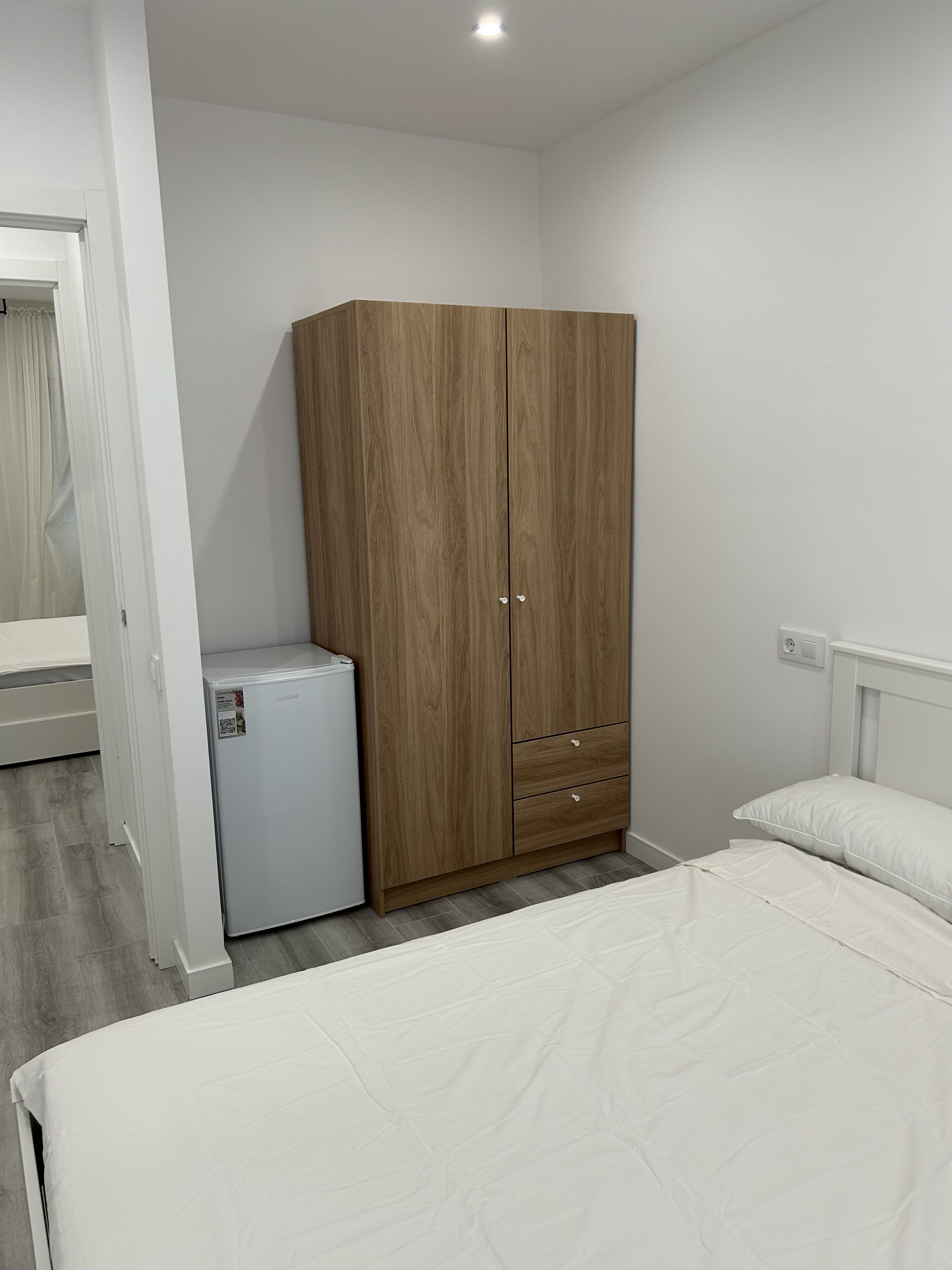 Dormitorio con armario y nevera