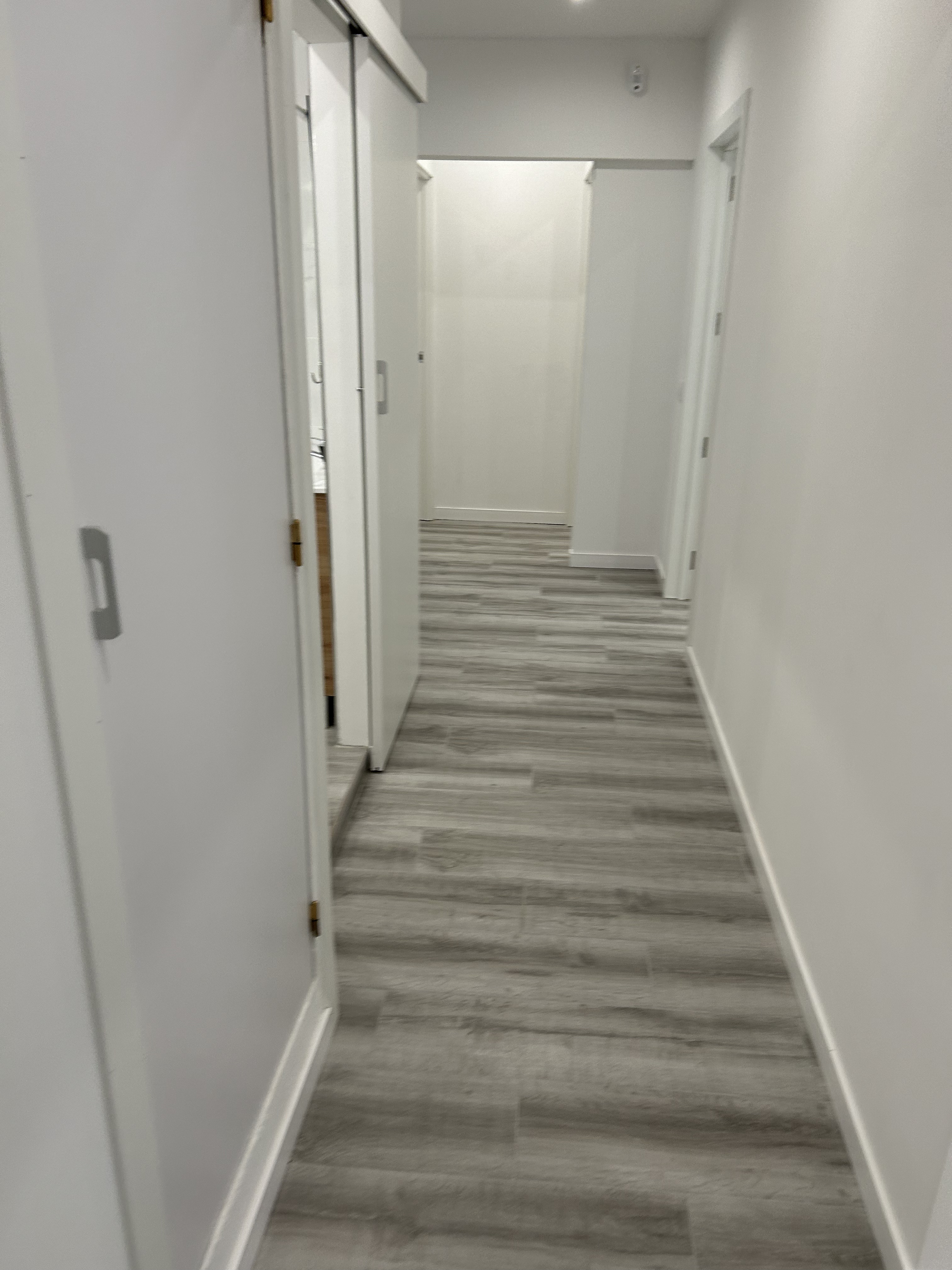 Pasillo con suelo laminado gris